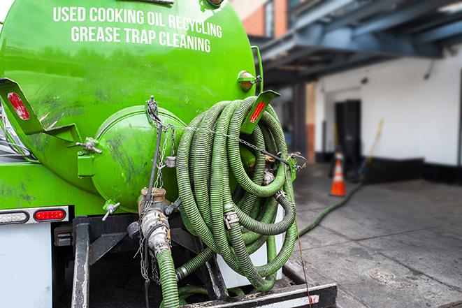 a grease trap pumping service in action at a commercial building in Ewing